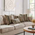 A living room setting featuring multiple Luxurious Landino Pillows in different sizes arranged on a beige sofa, highlighting their intricate green, beige, and brown woven patterns and adding a touch of elegance to the space.