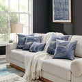 Elegant Erling Pillows arranged on a modern beige sofa, showcasing the stylish blue and white wave pattern in a contemporary living room setting.