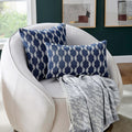 The Luxurious Lottolini Pillow in a navy wave pattern beautifully paired with a cozy armchair, enhancing the modern elegance of the seating area.
