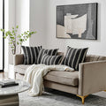 Luxurious Waterman Pillows arranged on a beige sofa in a modern living room setting.