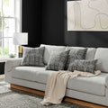 A minimalist living room featuring the Sophisticated Revamp Pillow in different sizes on a light gray couch, enhancing the decor.
